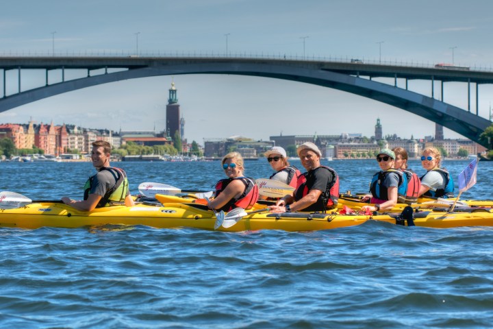 a group of people riding on the back of a boat in the water