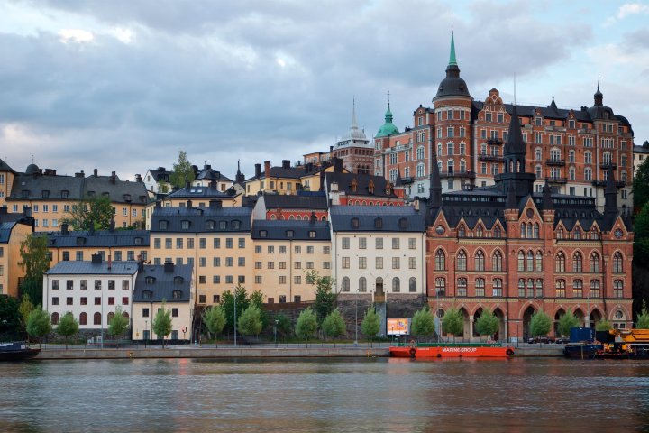 a small boat in a body of water with a city in the background