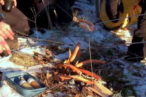 a person cooking food on a grill during an ice skating tour