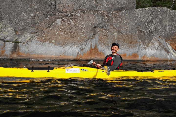 a man carrying a yellow surfboard on top of a body of water