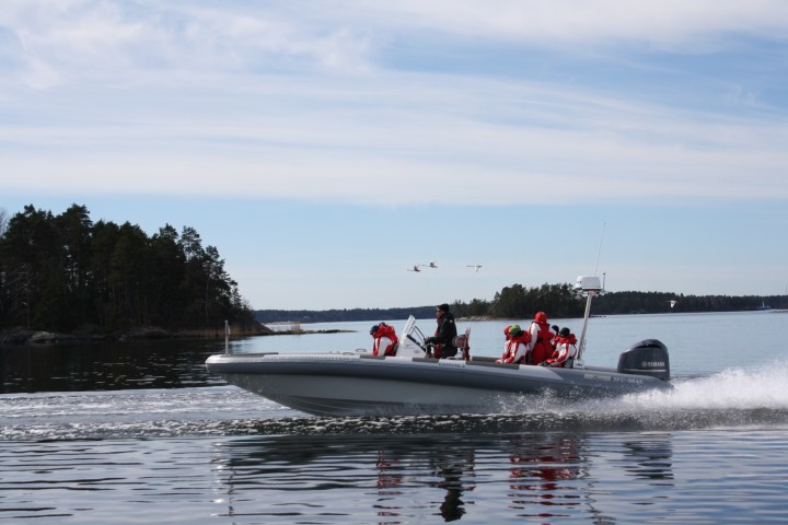 a group of people riding on the back of a boat in the water