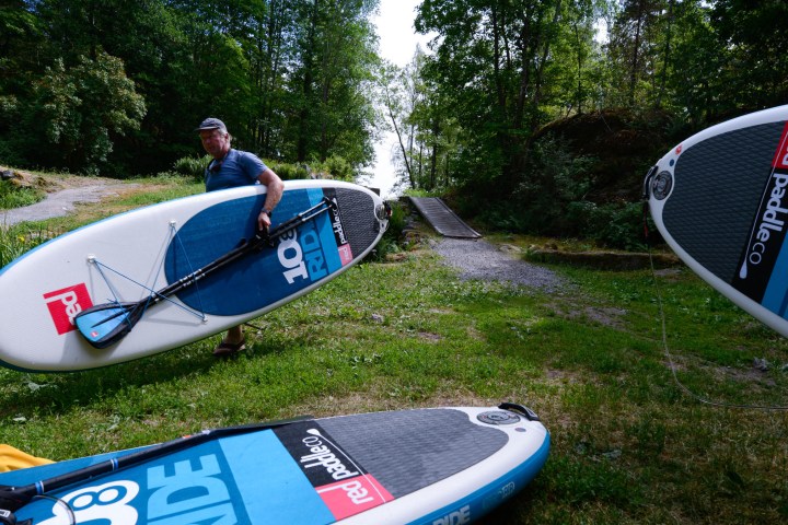 a man riding a surfboard on top of a grass covered field