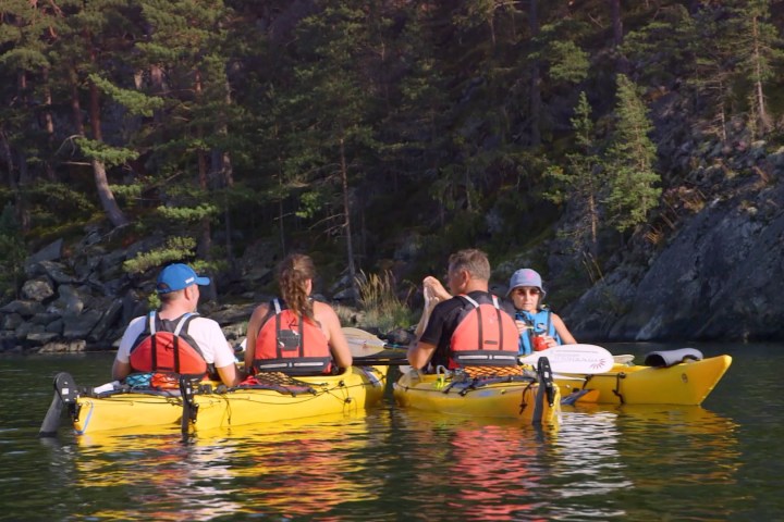 a group of people rowing a boat in the water
