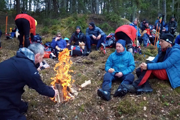 a group of people sitting while they are resting during their ice skating tour