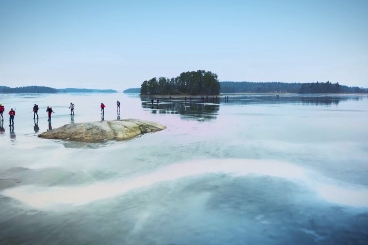 a group of people ice skating on natural ice