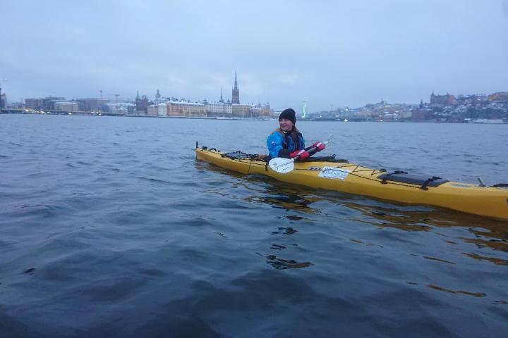 a man paddling on a kayak in Stockholm during the winter